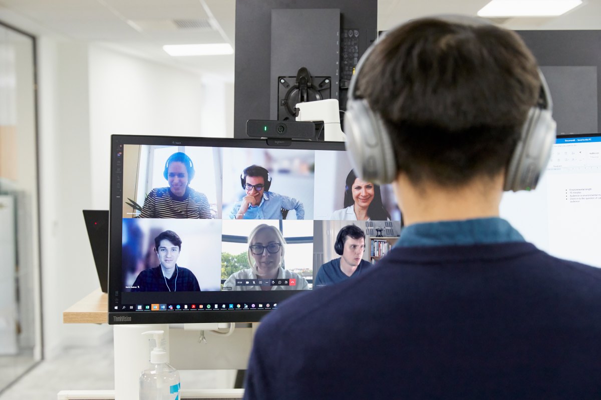 People on a zoom call on a laptop with a cup of coffee